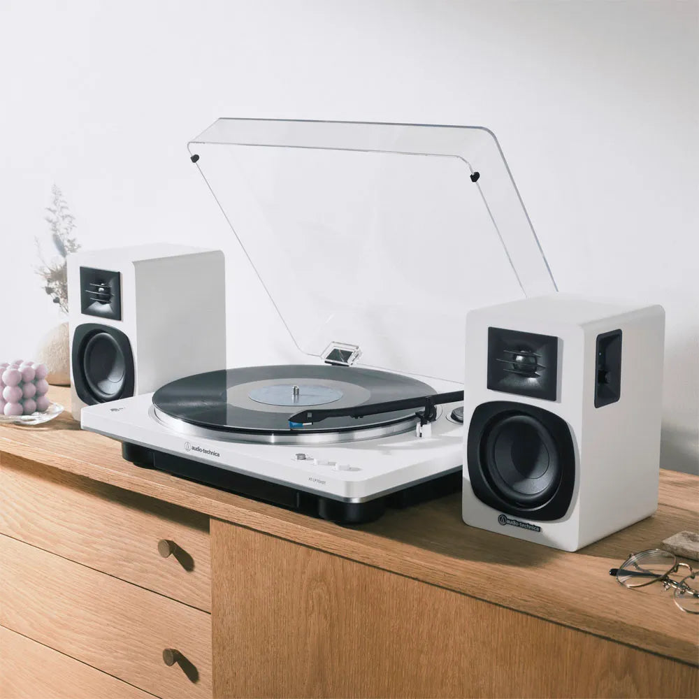 Altavoces AT-SP3X blancos conectados a una tornamesa